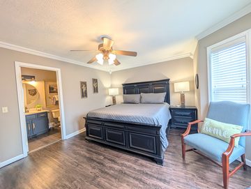 King bedroom with dark wood furniture and ensuite bathroom