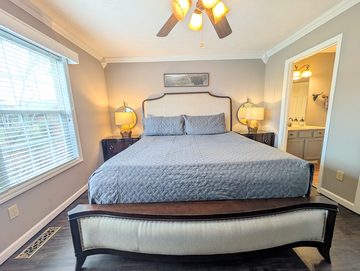 King bedroom with upholstered headboard and ensuite bathroom