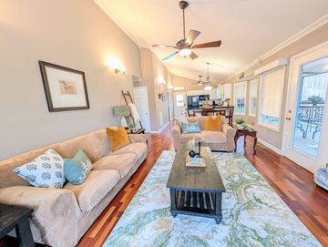 Living room with vaulted ceiling, open to the kitchen and dining area
